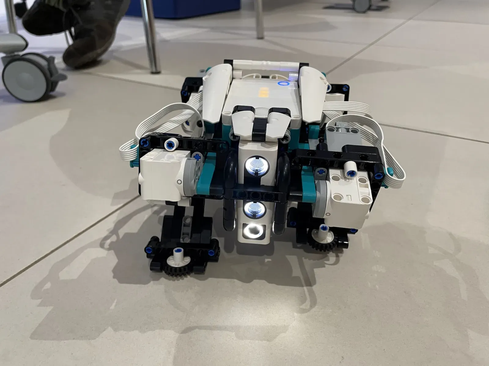 A LEGO Mindstorms robot built during an Intré learning guild, photographed on an office floor with its lights on.